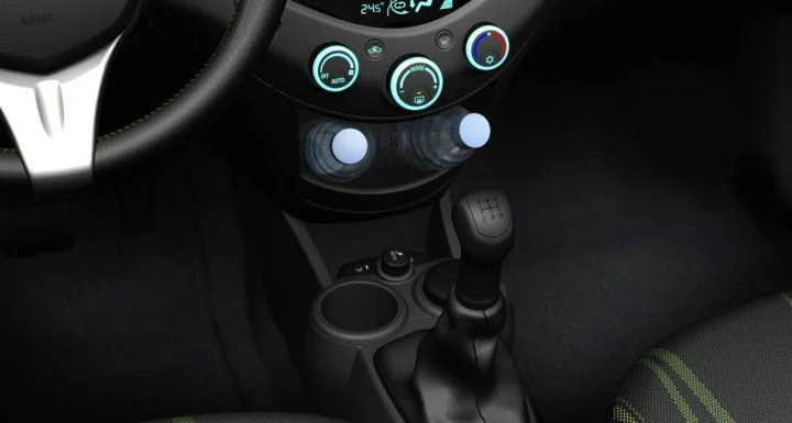 Consola central del Chevrolet Spark con control del aire acondicionado y palanca de cambios.