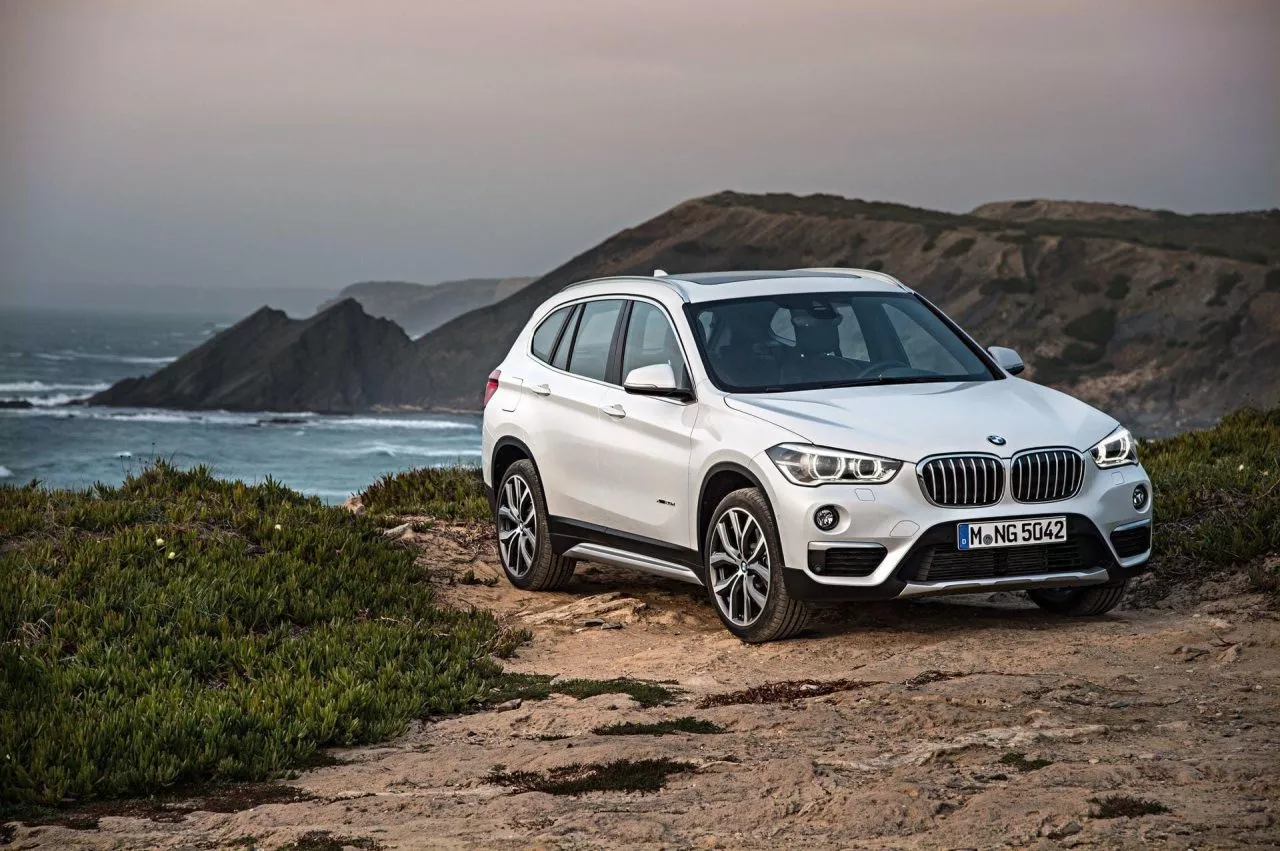 Vista lateral del BMW X1 en un entorno natural con el mar de fondo.