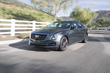 Vista dinámica del Cadillac ATS en movimiento mostrando su perfil delantero y lateral.