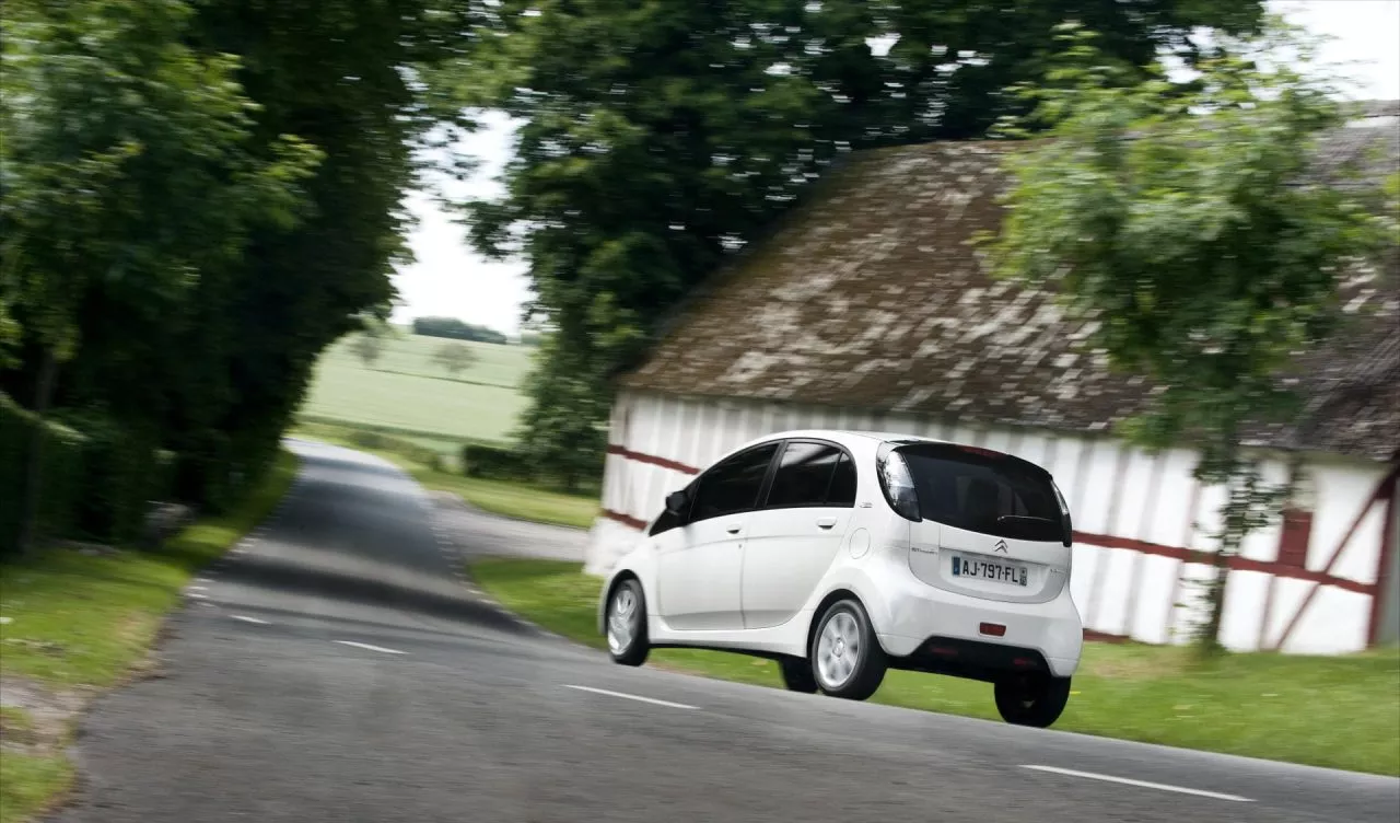 Vista lateral del Citroën C-Zero circulando por una carretera rural.