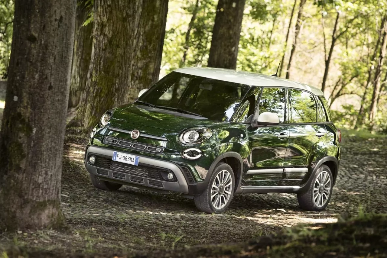 El Fiat 500L se abre camino entre la vegetación, mostrando su diseño lateral.