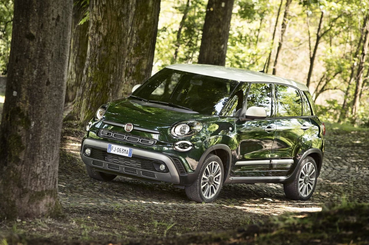 El Fiat 500L se abre camino entre la vegetación, mostrando su diseño lateral.