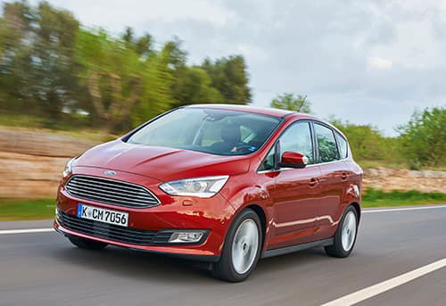 Vista dinámica del Ford C-MAX en movimiento, enfatizando su diseño frontal y lateral.