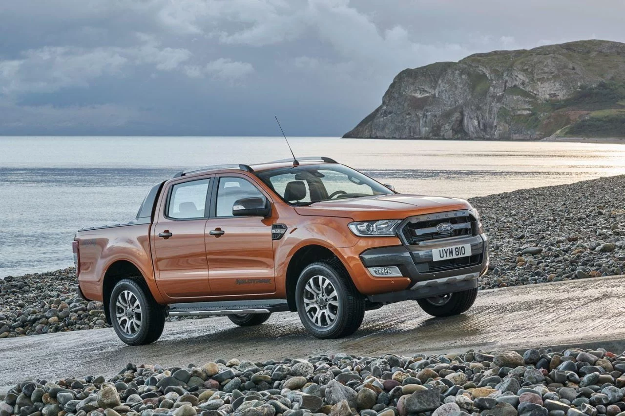 Vista lateral de un Ford Ranger en una playa, mostrando su perfil robusto.