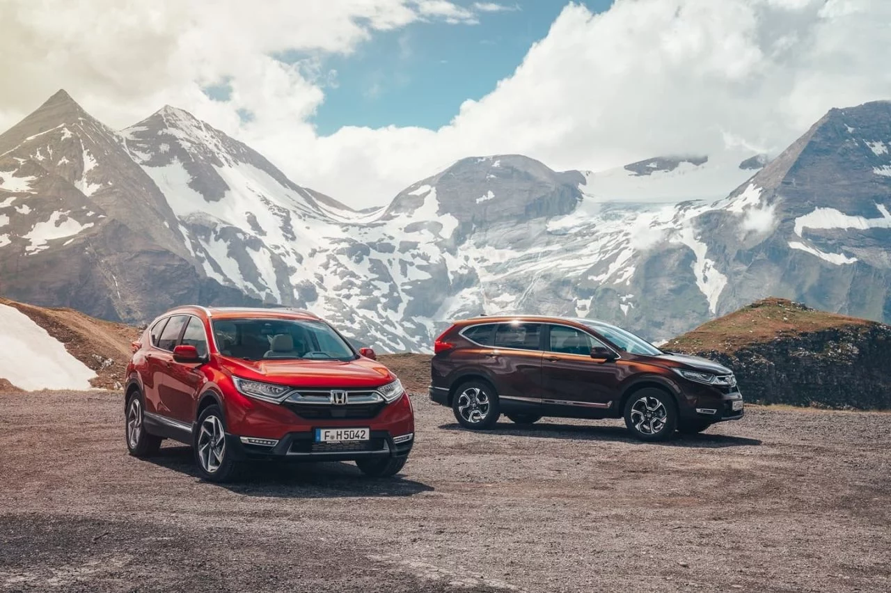 Vista frontal y lateral de dos Honda CR-V con montañas de fondo.