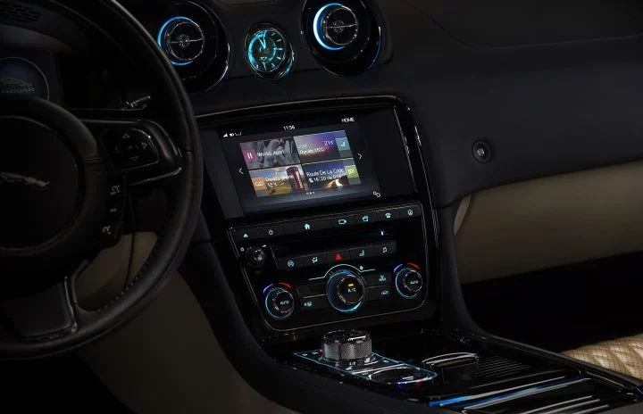 Vista del centro de control y sistema multimedia Jaguar XJ, enfatizando elegancia y tecnología.