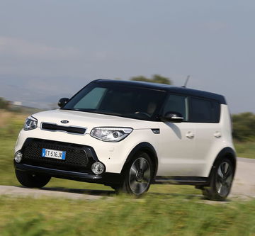 Vista dinámica del Kia e-Soul en movimiento, destacando su diseño lateral.