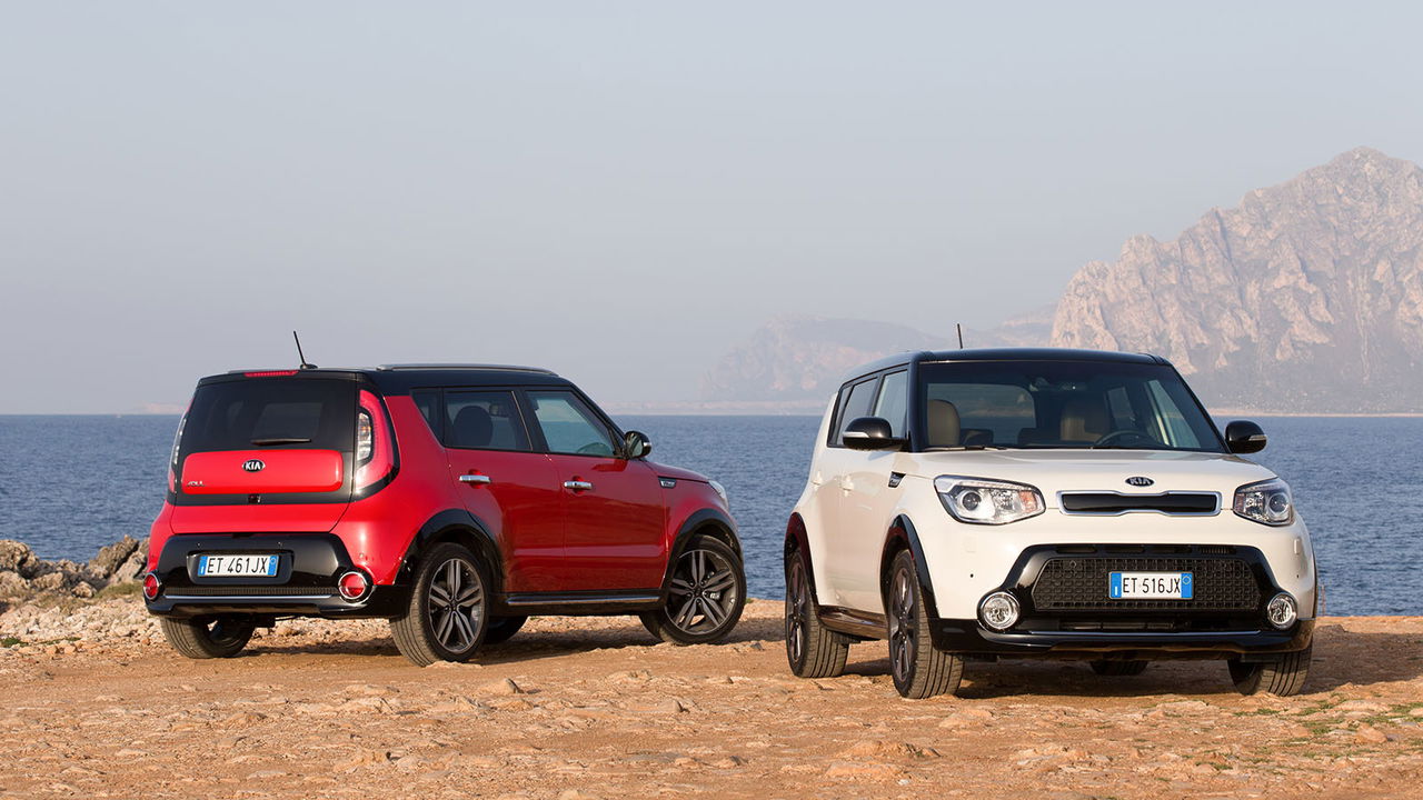 Vista lateral del Kia e-Soul en dos colores diferentes con fondo de playa.