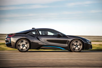 Vista lateral del BMW i8 en movimiento mostrando su línea aerodinámica.