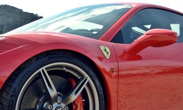 Vista lateral que resalta las llantas y la insignia del Ferrari 458 Italia.