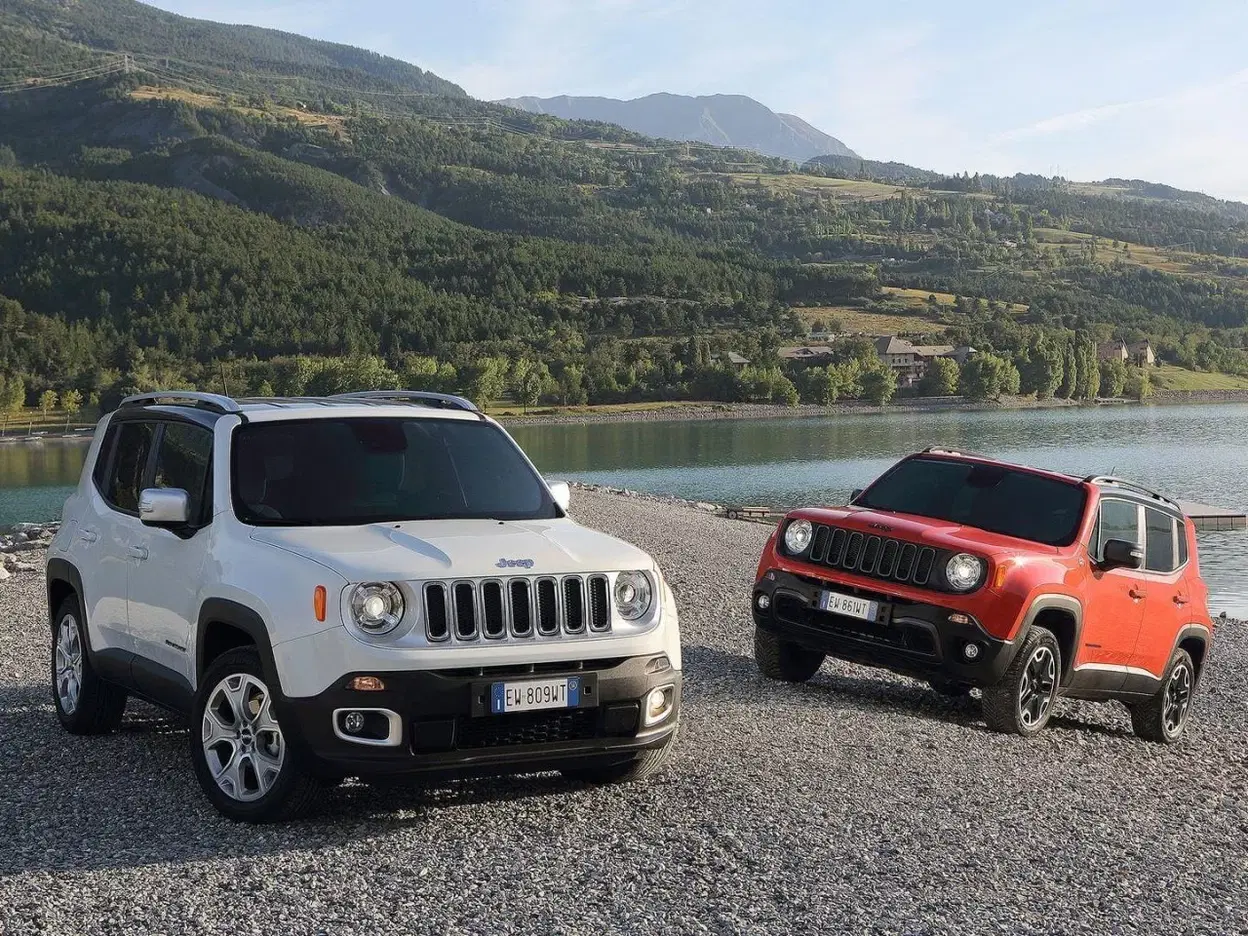 Vista de dos Jeep Renegade, uno blanco y otro rojo, en entorno natural.