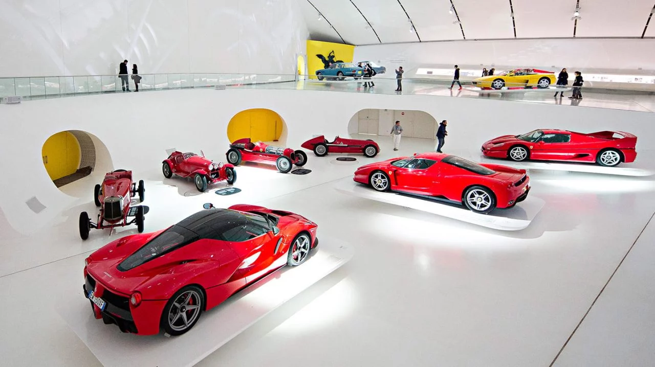 Vista lateral de un Ferrari F40 en una sala de exhibición junto a otros modelos de la marca.