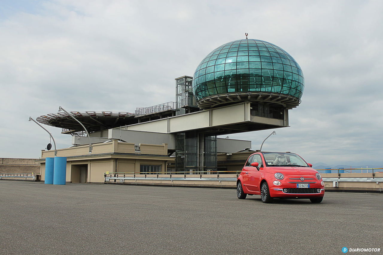 Vista lateral del Fiat 500 en un entorno de aeropuerto, destacando su diseño compacto.