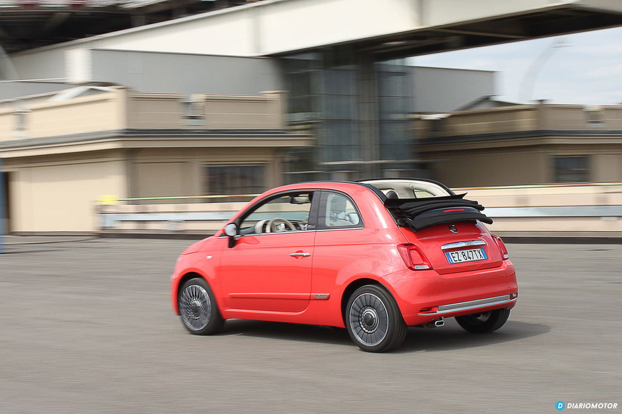 Vista lateral del Fiat 500 en movimiento, destacando su diseño compacto.