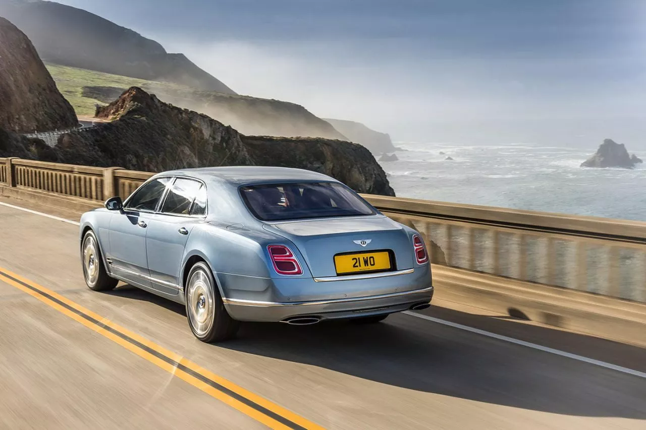 Vista dinámica del Bentley Mulsanne en carretera, destacando su elegante línea trasera.