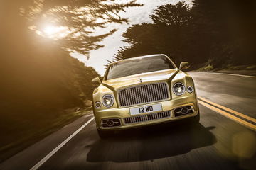 Vista frontal lateral del Bentley Mulsanne en carretera al atardecer.