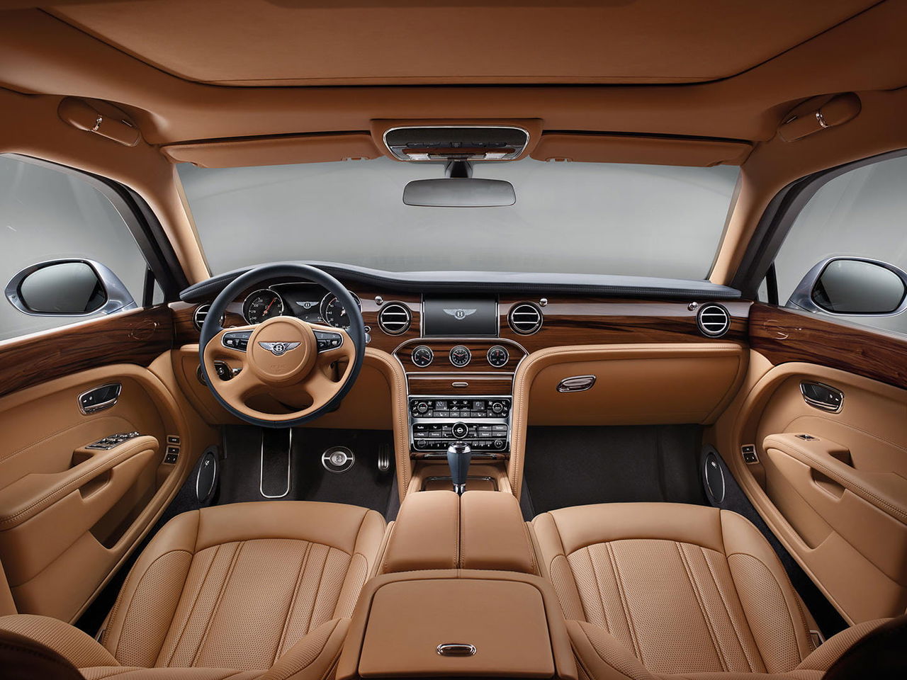 Vista frontal del lujoso habitáculo del Bentley Mulsanne, destacando su elegante tapicería y acabados en madera.