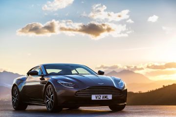 Vista dinámica del Aston Martin DB11 al atardecer, destacando su elegante diseño.