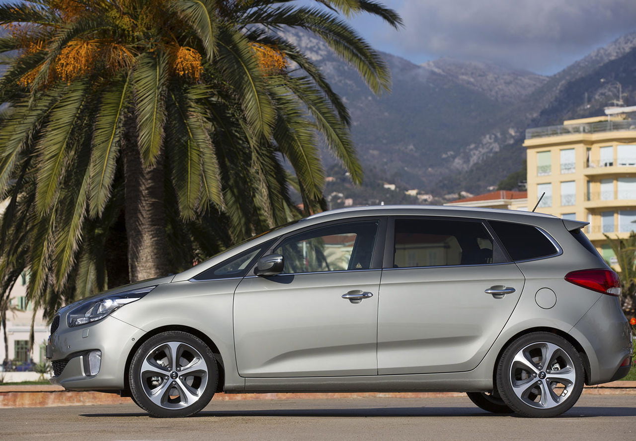 Vista lateral del Kia Carens resaltando su línea dinámica y diseño familiar.