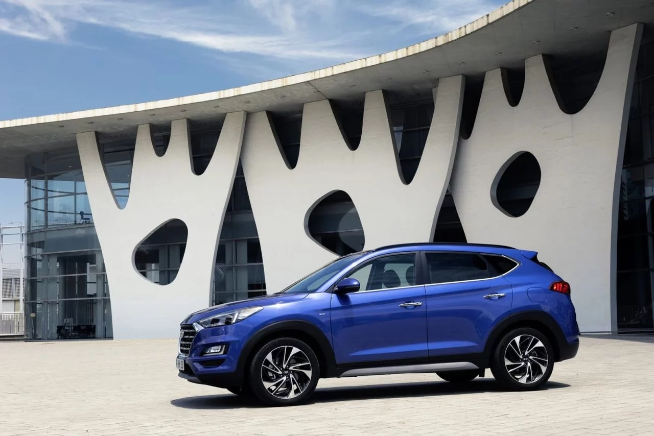 Vista lateral del Hyundai Tucson en un tono azul vibrante, destacando su diseño moderno