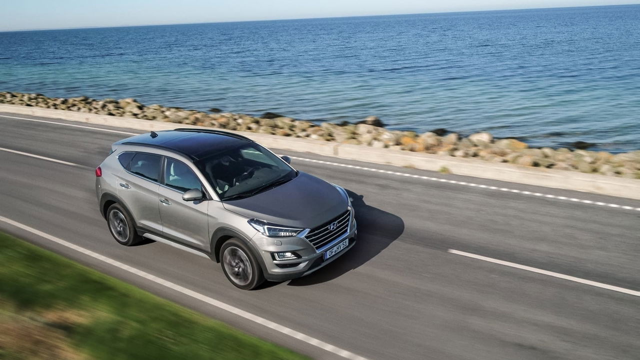 Vista lateral del Hyundai Tucson rodando junto al mar, destacando su diseño aerodinámico.