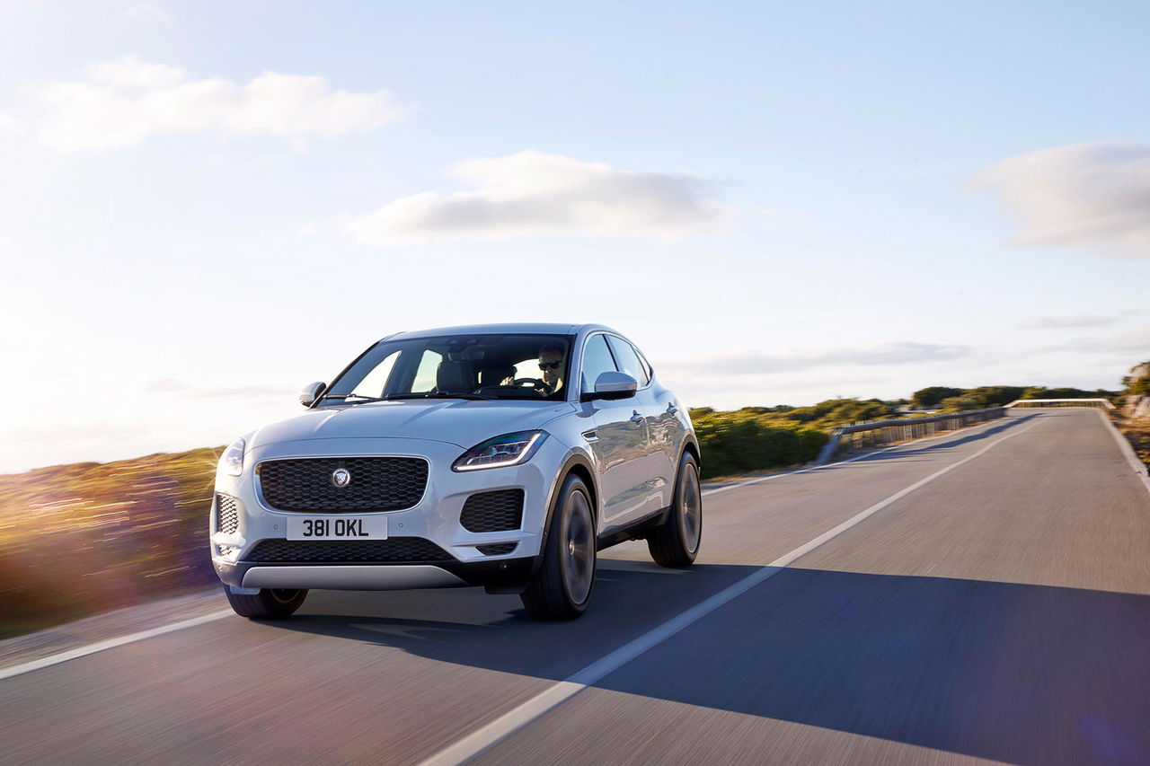 Vista dinámica Jaguar E-PACE rodando por carretera, énfasis diseño frontal y lateral.