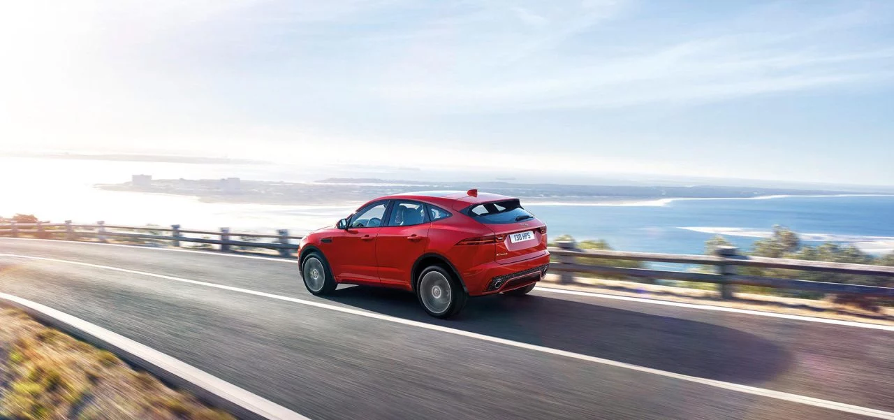 Vista lateral del Jaguar E-PACE rodando por la carretera costera.