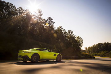 Aston Martin Vantage desplegando potencia en circuito, vista frontal lateral.