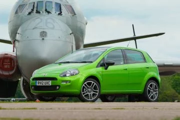 Vista lateral del Fiat Punto en color verde destacando su diseño compacto y urbano.
