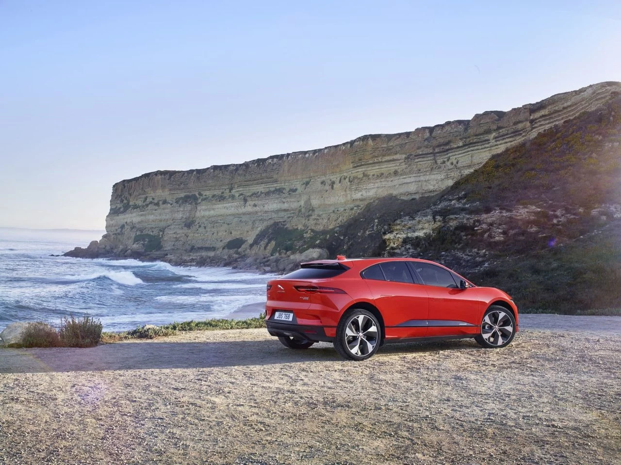 Vista lateral del Jaguar I-PACE en entorno natural, mostrando su línea aerodinámica.