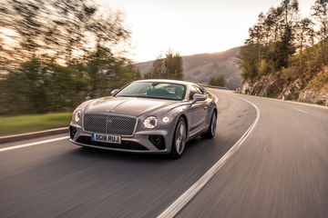 Vista lateral del Bentley Continental GT en un paisaje montañoso.