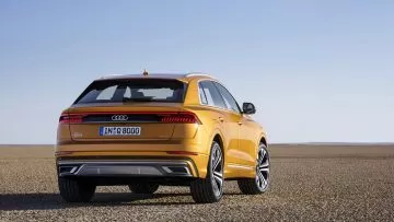 Vista trasera y lateral del Audi Q8 en color amarillo.