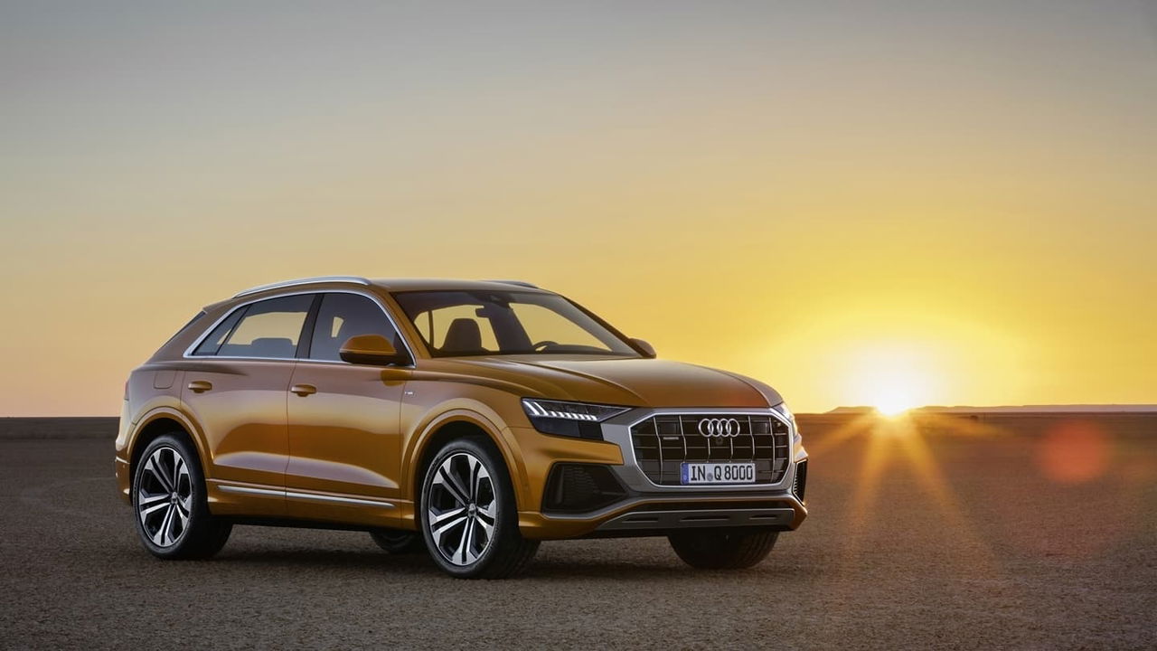 Perfil elegante del Audi Q8 con puesta de sol de fondo.