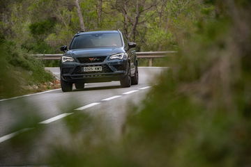 Vista frontal del CUPRA Ateca avanzando por una carretera boscosa