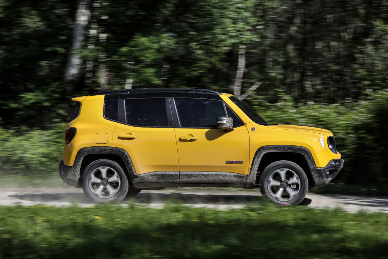 Vista lateral del Jeep Renegade en un entorno boscoso, resaltando su diseño y color vibrante