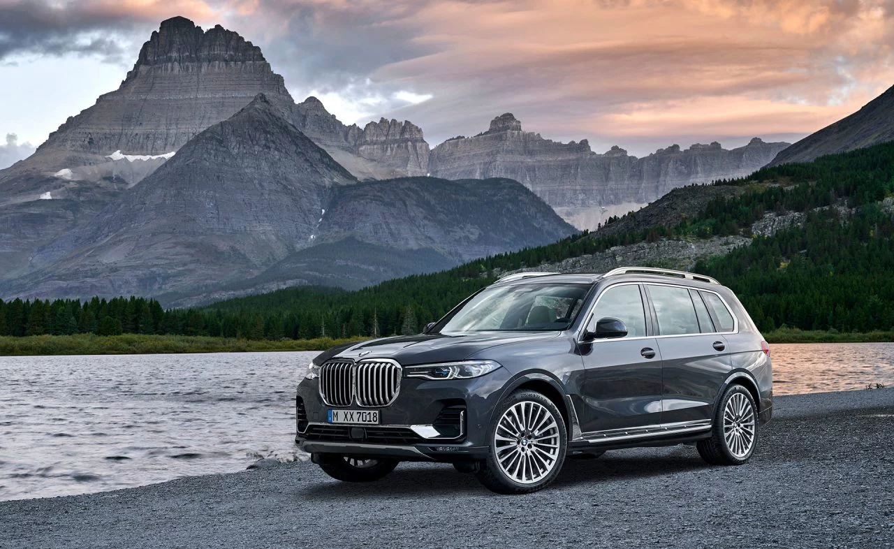 Vista lateral del BMW X7 con montañas al fondo, destacando su diseño robusto.