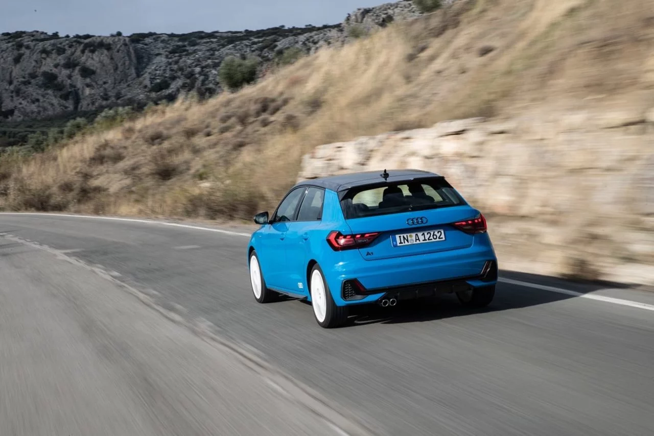 Vista dinámica trasera lateral del Audi A1 en movimiento, destacando su deportividad.