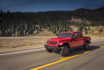 Jeep Gladiator avanzando por carretera de montaña, mostrando su perfil lateral.