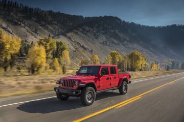 Jeep Gladiator rojo en marcha, vista lateral que resalta su diseño y capacidad off-road.