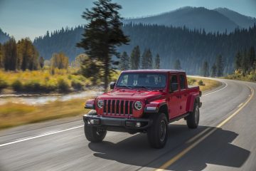Vista lateral del Jeep Gladiator en rojo dinámica por carretera de montaña.