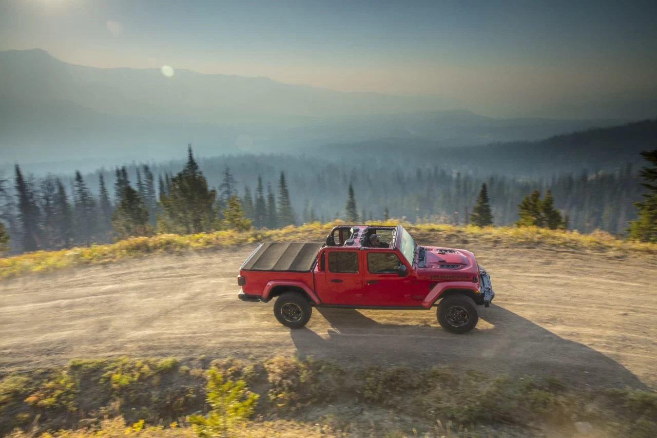 Vista lateral del Jeep Gladiator en un entorno montañoso demostrando su capacidad off-road.