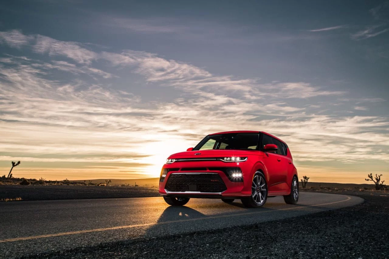 Kia e-Soul captado en un atardecer, mostrando su diseño lateral y frontal.