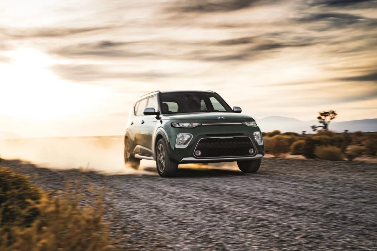 Vista frontal del Kia e-Soul rodando por una carretera al atardecer, destacando su diseño vanguardista.