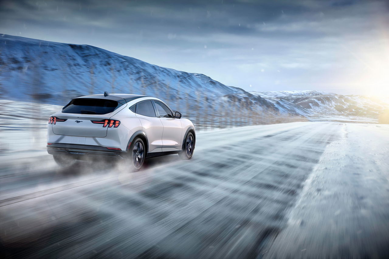 Vista dinámica del Ford Mustang Mach-E en carretera nevada.