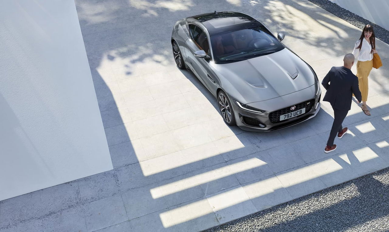 Vista aérea del Jaguar F-Type abordando un cruce urbano, realzando su diseño aerodinámico.