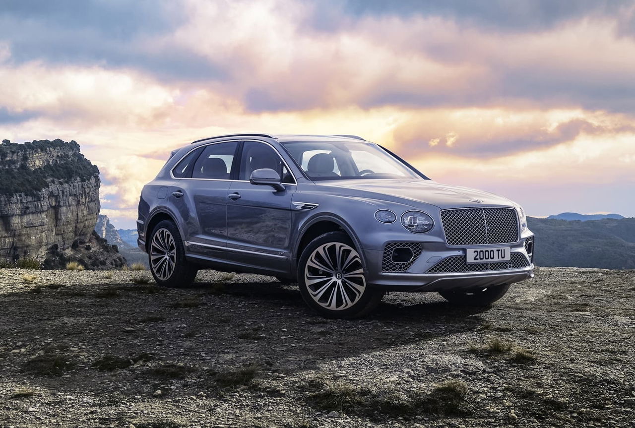 Vista lateral delantera del Bentley Bentayga en un paisaje natural.