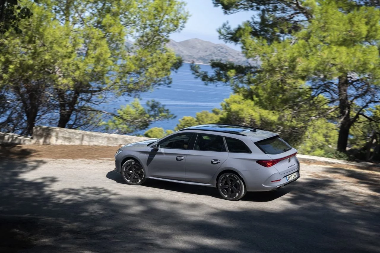 Vista lateral del CUPRA León aparcado en un entorno natural.