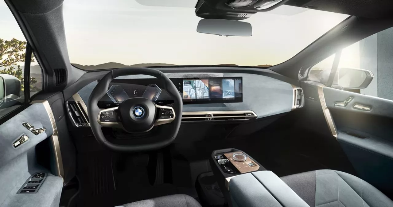 Cabina futurista del BMW iX con volante y panel de instrumentos digitales.