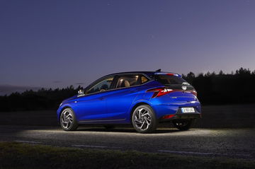 Vista lateral del Hyundai i20 iluminado en escenario nocturno.