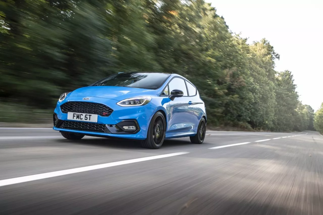 Vista dinámica del Ford Fiesta en carretera, destacando su diseño frontal y lateral.